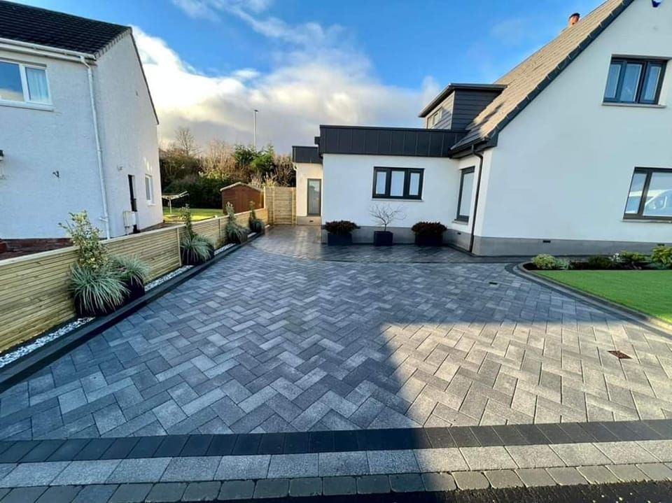 Grey block paving outside a white house