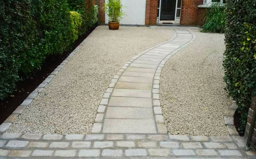 Curved stone pathway beside a green hedge